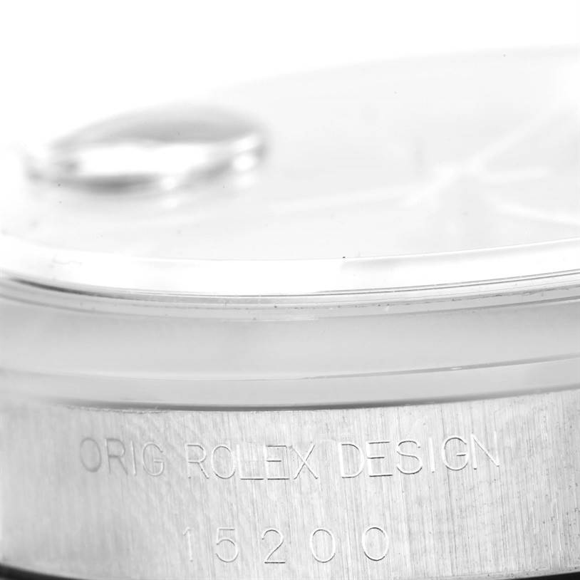 The image shows a close-up side view of a Rolex Date 15200 Men's Stainless Steel Blue Dial 15200 Men's Stainless Steel Blue Dial model watch, highlighting the bezel and part of the case with "ORIG ROLEX DESIGN" and model number engraved.