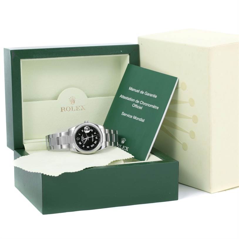 The image shows a Rolex Date 115200 Men's Stainless Steel Black Dial 115200 Men's Stainless Steel Black Dial model watch in its open box, accompanied by a manual and warranty booklet.