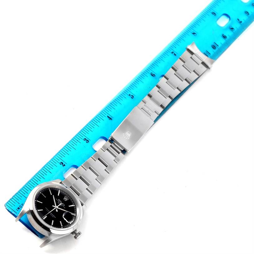 The Rolex Date 15200 Men's Stainless Steel Black Dial 15200 Men's Stainless Steel Black Dial model watch is shown lying flat next to a ruler, displaying the face, bracelet, and clasp.