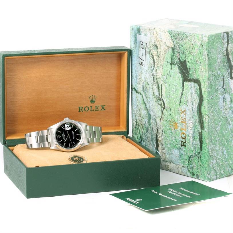 The image shows a Rolex Date 15200 Men's Stainless Steel Black Dial 15200 Men's Stainless Steel Black Dial model watch inside its opened box, along with the outer packaging and accompanying documents.