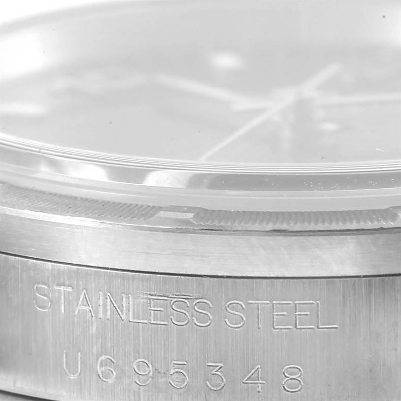 This image shows a macro view of the side of a Rolex Date 15210 Men's Stainless Steel Blue Dial 15210 Men's Stainless Steel Blue Dial model watch, highlighting its stainless steel casing and part of the bezel.