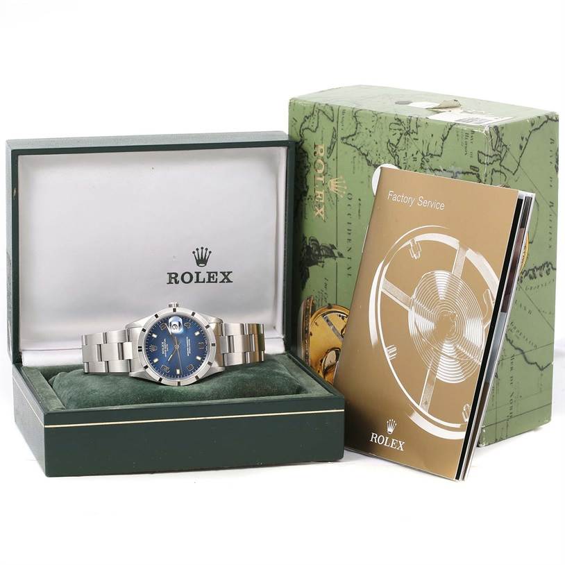 The Rolex Date 15210 Men's Stainless Steel Blue Dial 15210 Men's Stainless Steel Blue Dial model watch is shown in its box, accompanied by a factory service booklet.