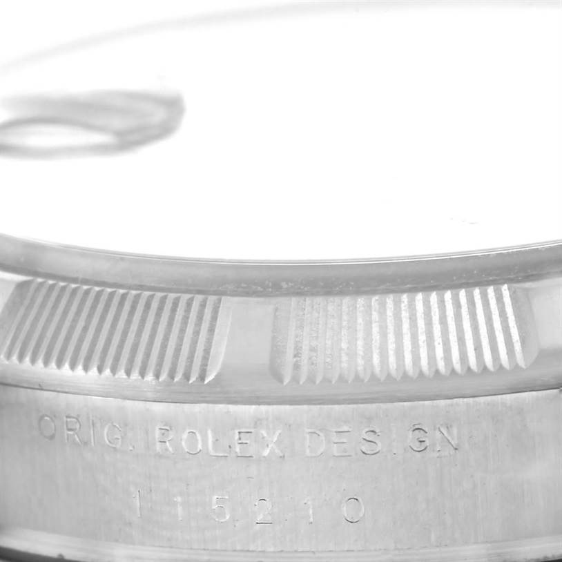This image shows a close-up of the bezel and engraved side of a Rolex Date 115210 Men's Stainless Steel White Dial 115210 Men's Stainless Steel White Dial model watch.