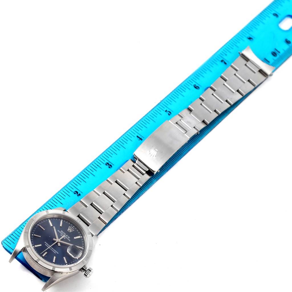 The Rolex Date 15210 Men's Stainless Steel Blue Dial 15210 Men's Stainless Steel Blue Dial watch is displayed flat with an extended stainless steel bracelet measured against a ruler.