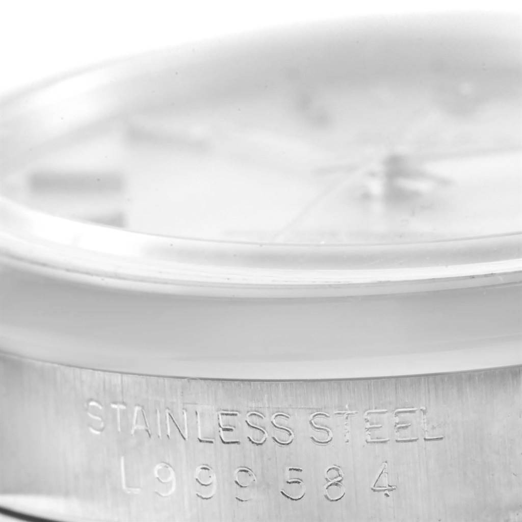 The image shows a side-view angle of a Rolex Date 15200 Men's Stainless Steel Silver Dial 15200 Men's Stainless Steel Silver Dial model's case, focusing on its stainless steel band engraving.