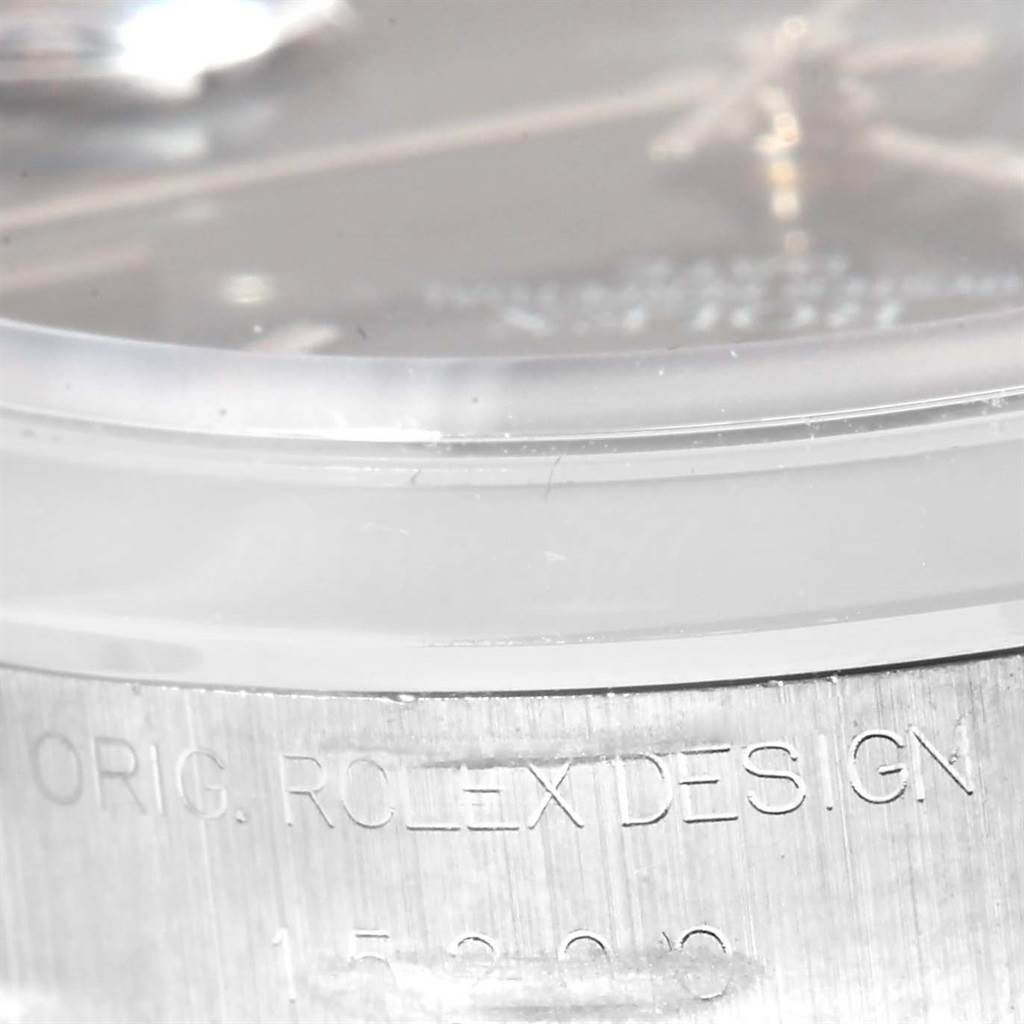 This image shows a close-up of the side of a Rolex Date 15200 Men's Stainless Steel Blue Dial 15200 Men's Stainless Steel Blue Dial model watch, displaying the etched text "ORIG. ROLEX DESIGN."