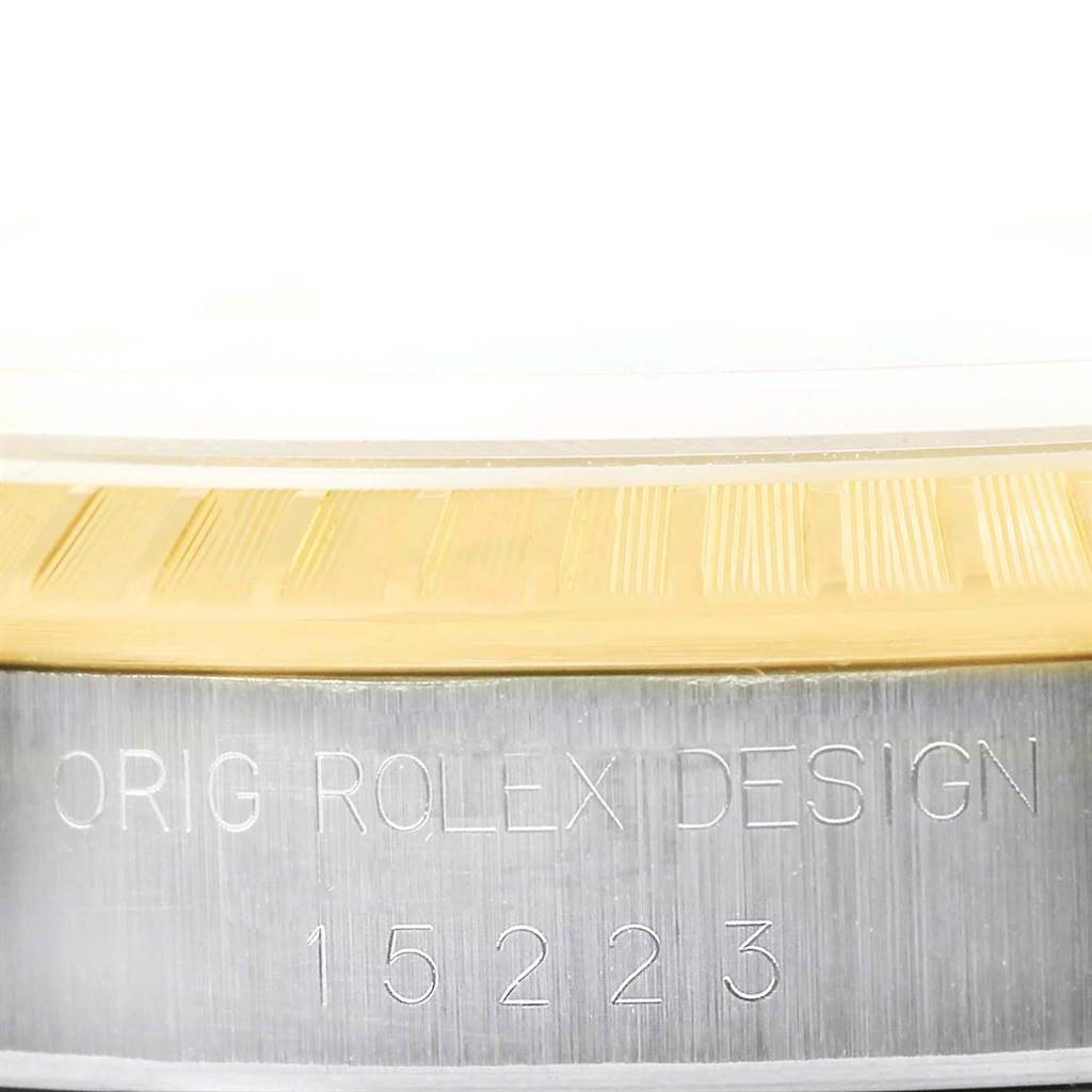 This image shows a close-up of the side view of a Rolex Date 15223 Men
s Steel and Gold (two tone) White Dial 15223 Men
s Steel and Gold (two tone) White Dial model, featuring the serial number and "ORIG ROLEX DESIGN" engraving.