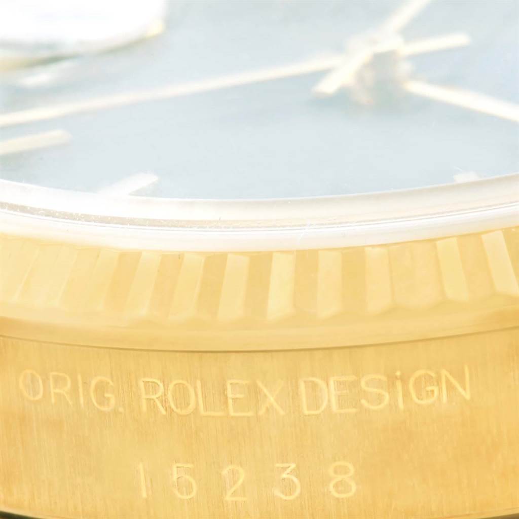 This close-up shows the bezel, part of the dial, and the engraved case of the Rolex Date 15238 Men's Yellow Gold Blue Dial 15238 Men's Yellow Gold Blue Dial model.
