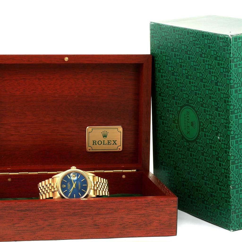 The Rolex Date 15238 Men's Yellow Gold Blue Dial 15238 Men's Yellow Gold Blue Dial model watch is shown in an open wooden box with green detailing on the inner lid and an outer green box.