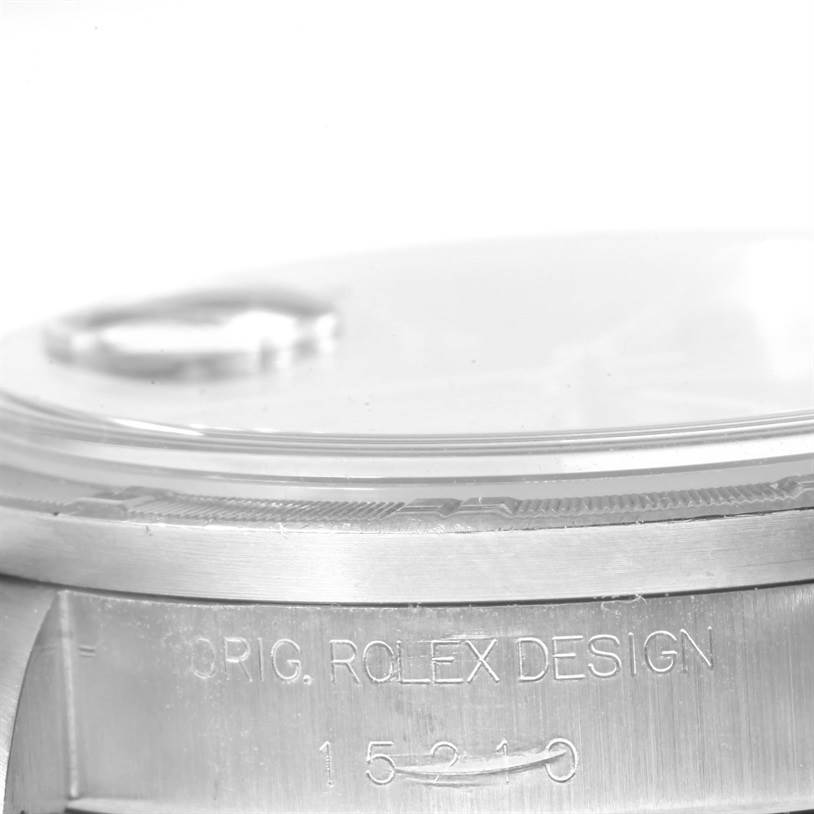 This close-up image of a Rolex Date 15210 Men's Stainless Steel Blue Dial 15210 Men's Stainless Steel Blue Dial model watch shows the case side engraving and part of the crystal with a cyclops lens.