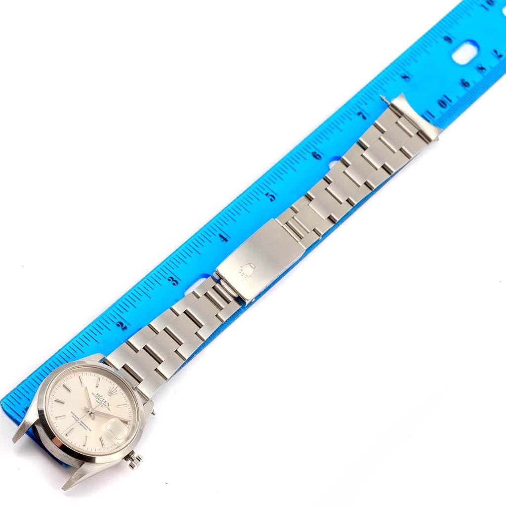 The image shows a Rolex Date 15200 Men
s Stainless Steel Silver Dial 15200 Men
s Stainless Steel Silver Dial model watch laid flat next to a blue ruler, revealing its face, bezel, lugs, and bracelet.