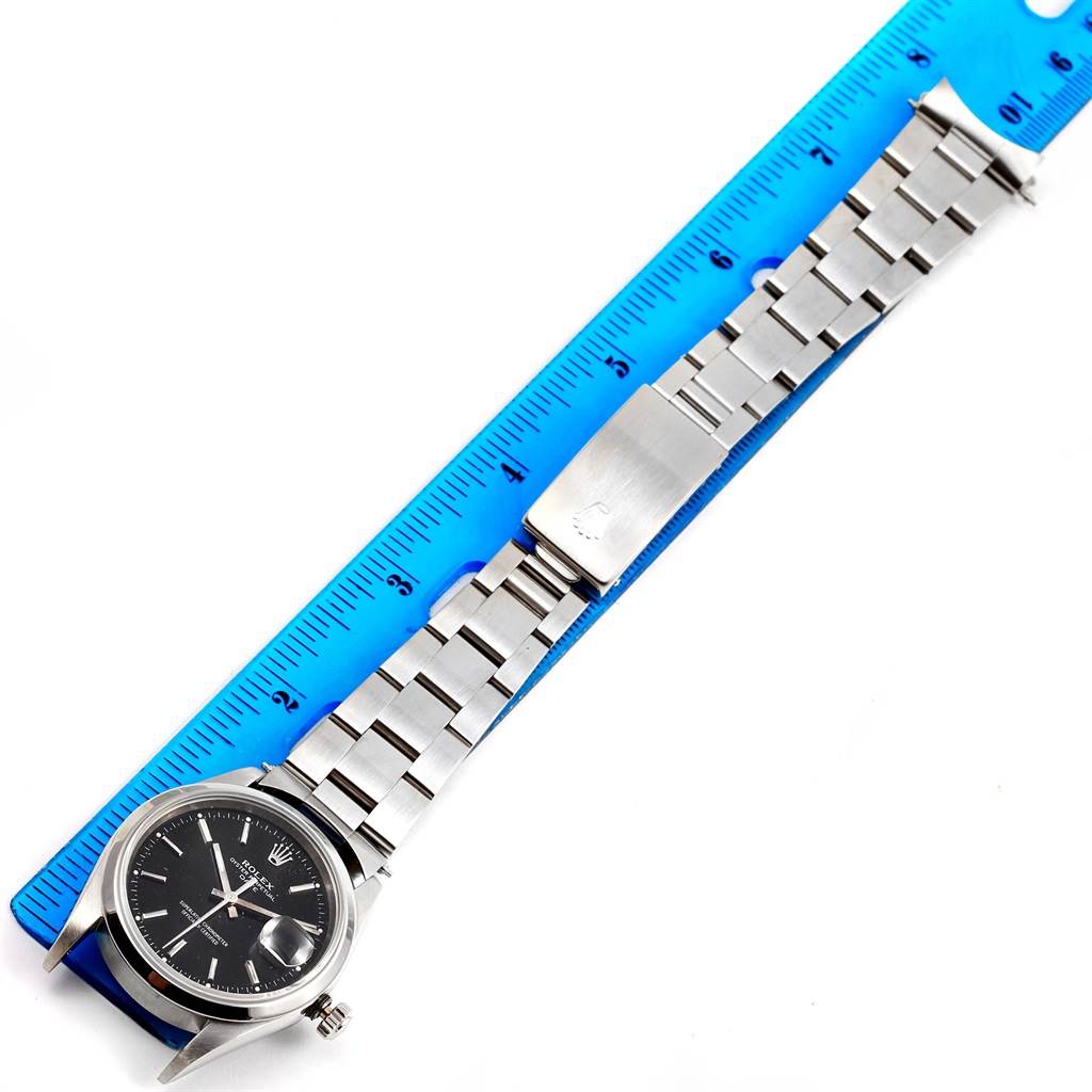 The Rolex Date 15200 Men's Stainless Steel Black Dial 15200 Men's Stainless Steel Black Dial watch is shown flat, with a focus on the bracelet and clasp aligned against a blue ruler.