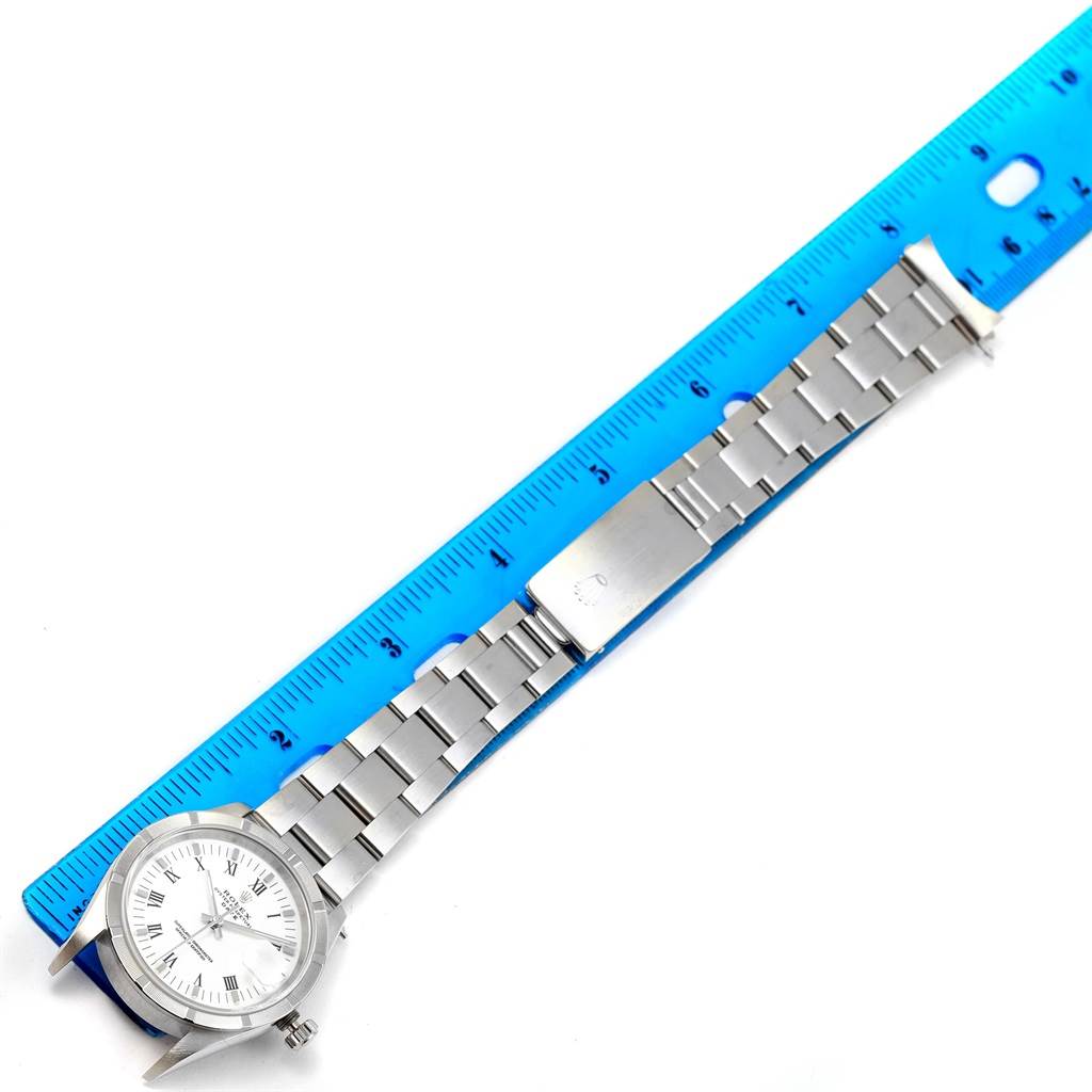 This Rolex Date 15210 Men's Stainless Steel White Dial 15210 Men's Stainless Steel White Dial watch is shown from a top-down angle, displaying the face, bracelet, and part of the clasp alongside a ruler for scale.