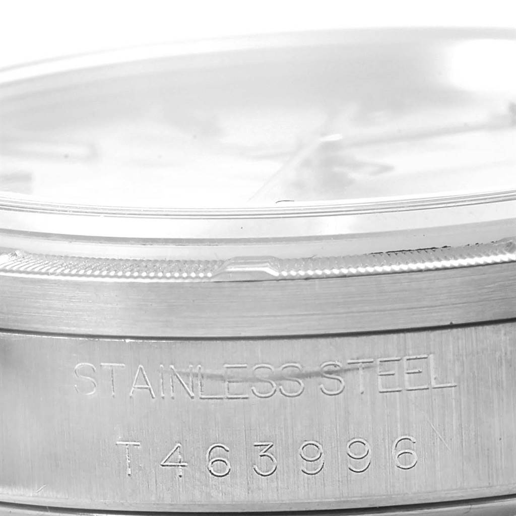 The image shows a side view of a Rolex Date 15210 Men's Stainless Steel Silver Dial 15210 Men's Stainless Steel Silver Dial model watch, focusing on its stainless steel case with the serial number.