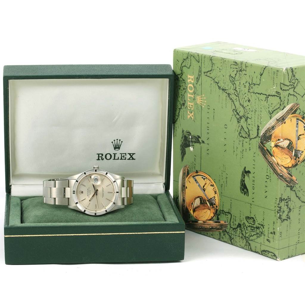 The Rolex Date 15210 Men's Stainless Steel Silver Dial 15210 Men's Stainless Steel Silver Dial model watch is shown from the front, inside its green box next to its original packaging.