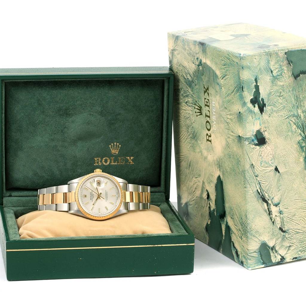 The Rolex Date 15223 Men's Steel and Gold (two tone) Silver Dial 15223 Men's Steel and Gold (two tone) Silver Dial model watch is shown from the front, inside its original box with visible packaging beside it.