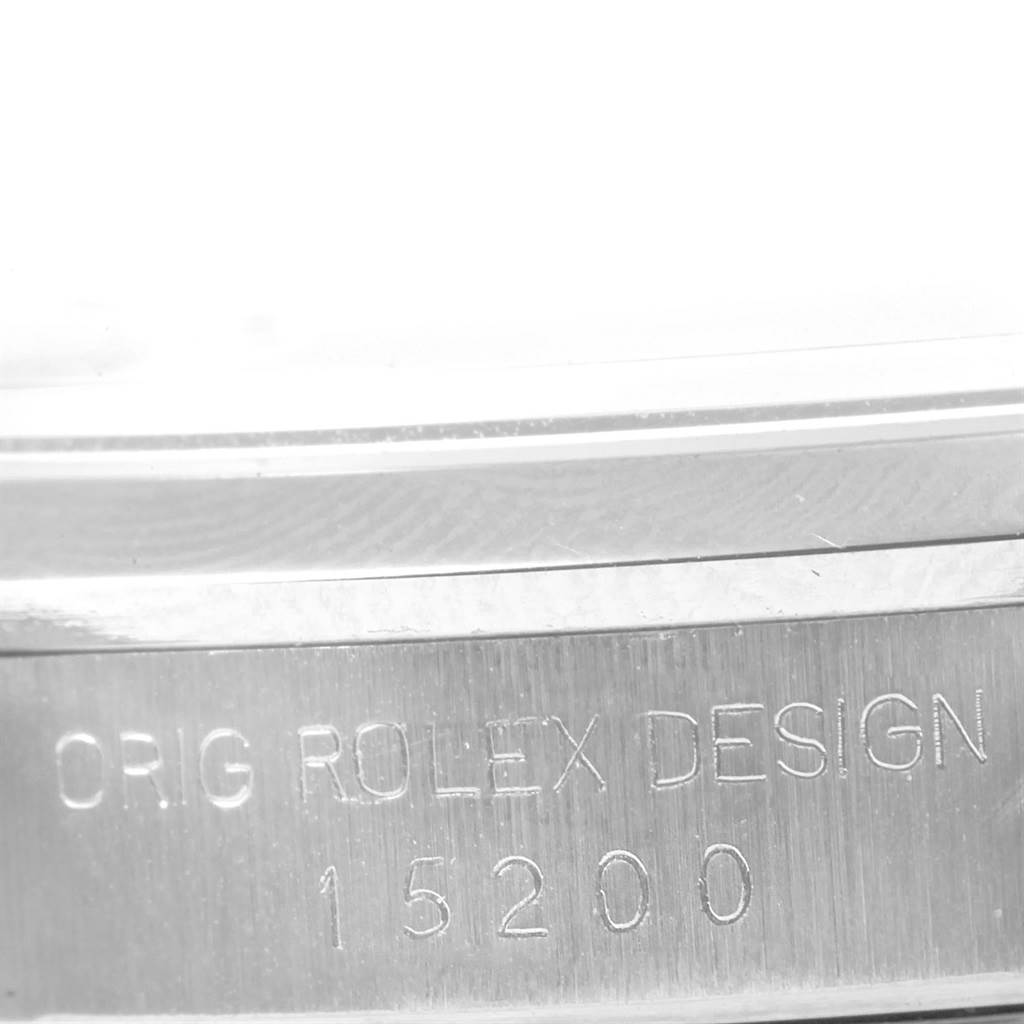 The image shows a close-up angle of a Rolex Date 15200 Men's Stainless Steel Silver Dial 15200 Men's Stainless Steel Silver Dial model, focusing on the engraved serial number 15200 and "ORIG ROLEX DESIGN" text.