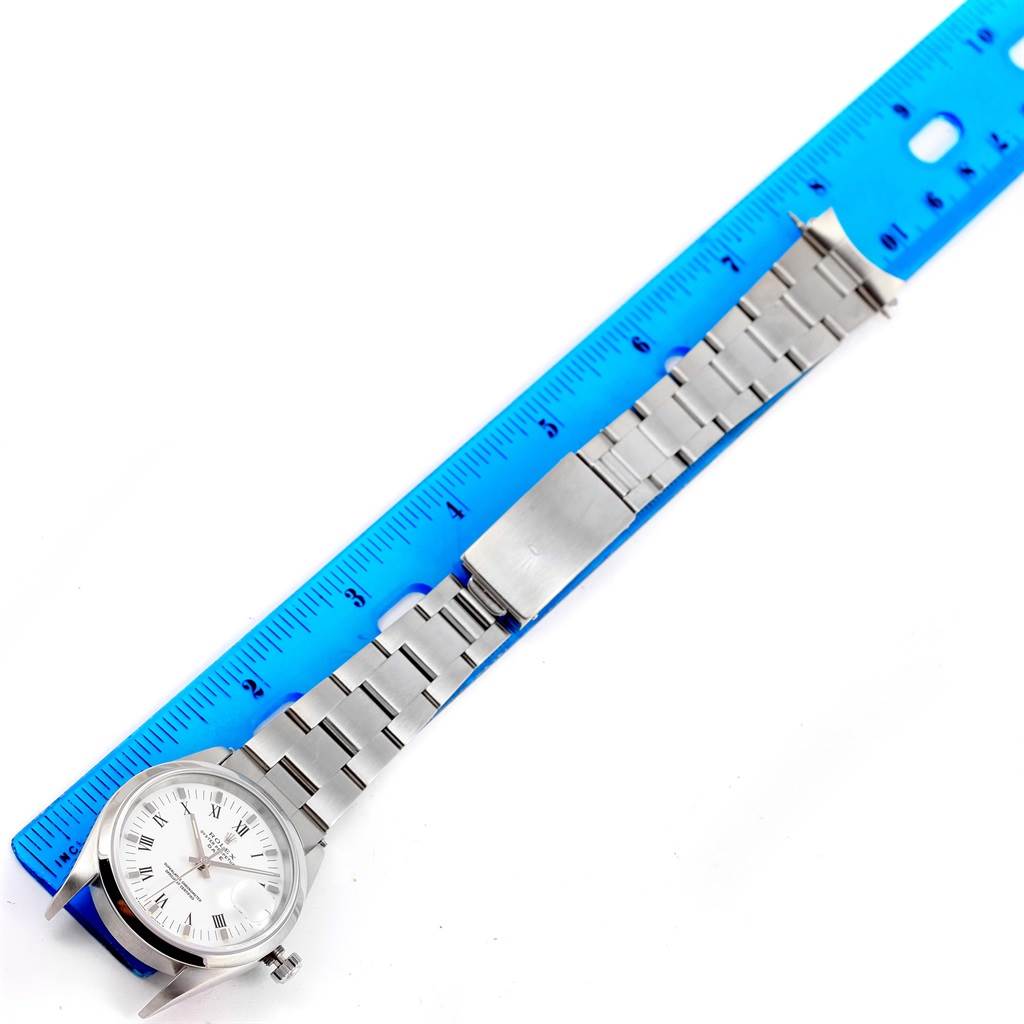 The image shows a Rolex Date 15200 Men's Stainless Steel White Dial 15200 Men's Stainless Steel White Dial model watch laid flat next to a blue ruler, highlighting its bracelet and clasp.