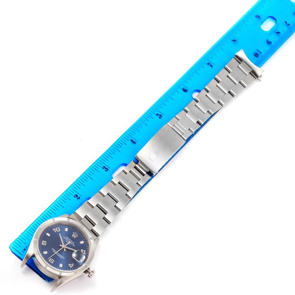 The image shows a Rolex Date 15210 Men's Stainless Steel Blue Dial 15210 Men's Stainless Steel Blue Dial model watch laid flat alongside a blue ruler for measurement.