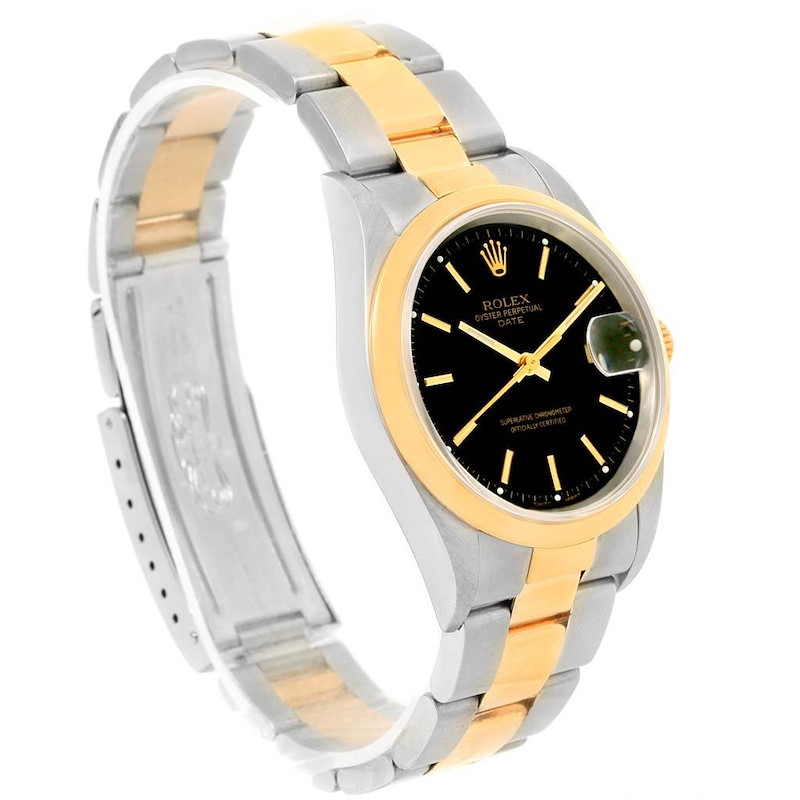 This image shows a side angle of a Rolex Date model watch, highlighting its black dial, gold bezel, and two-tone bracelet.