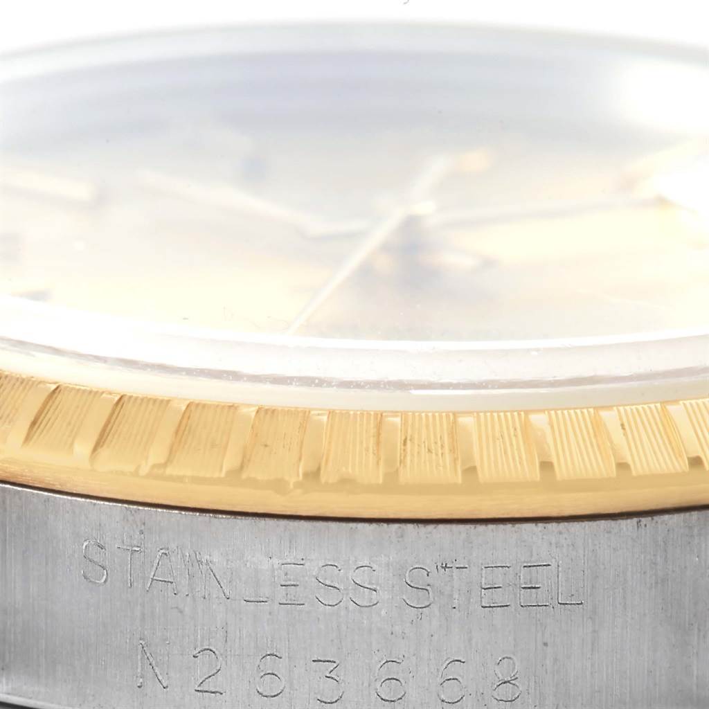 This image shows a close-up of the stainless steel case and gold fluted bezel of a Rolex Date 15223 Men's Steel and Gold (two tone) Champagne Dial 15223 Men's Steel and Gold (two tone) Champagne Dial model watch.