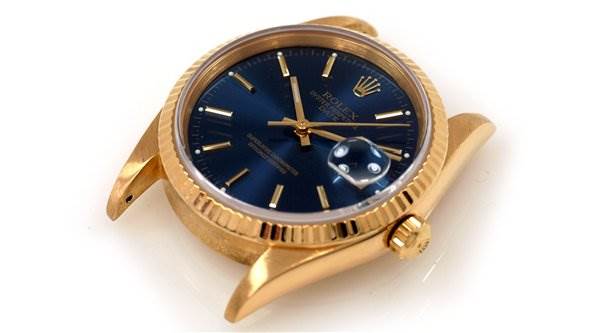 This image shows a Rolex Date 15238 Men's Yellow Gold Blue Dial 15238 Men's Yellow Gold Blue Dial watch case and dial at a slight angle, highlighting the crown and fluted bezel.
