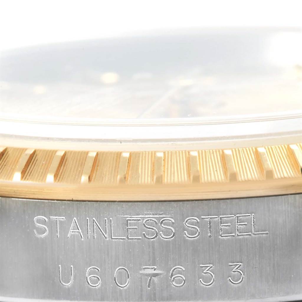 This image shows a close-up of the stainless steel and gold bezel with the serial number of a Rolex Date 15223 Men's Steel and Gold (two tone) Champagne Dial 15223 Men's Steel and Gold (two tone) Champagne Dial model watch.