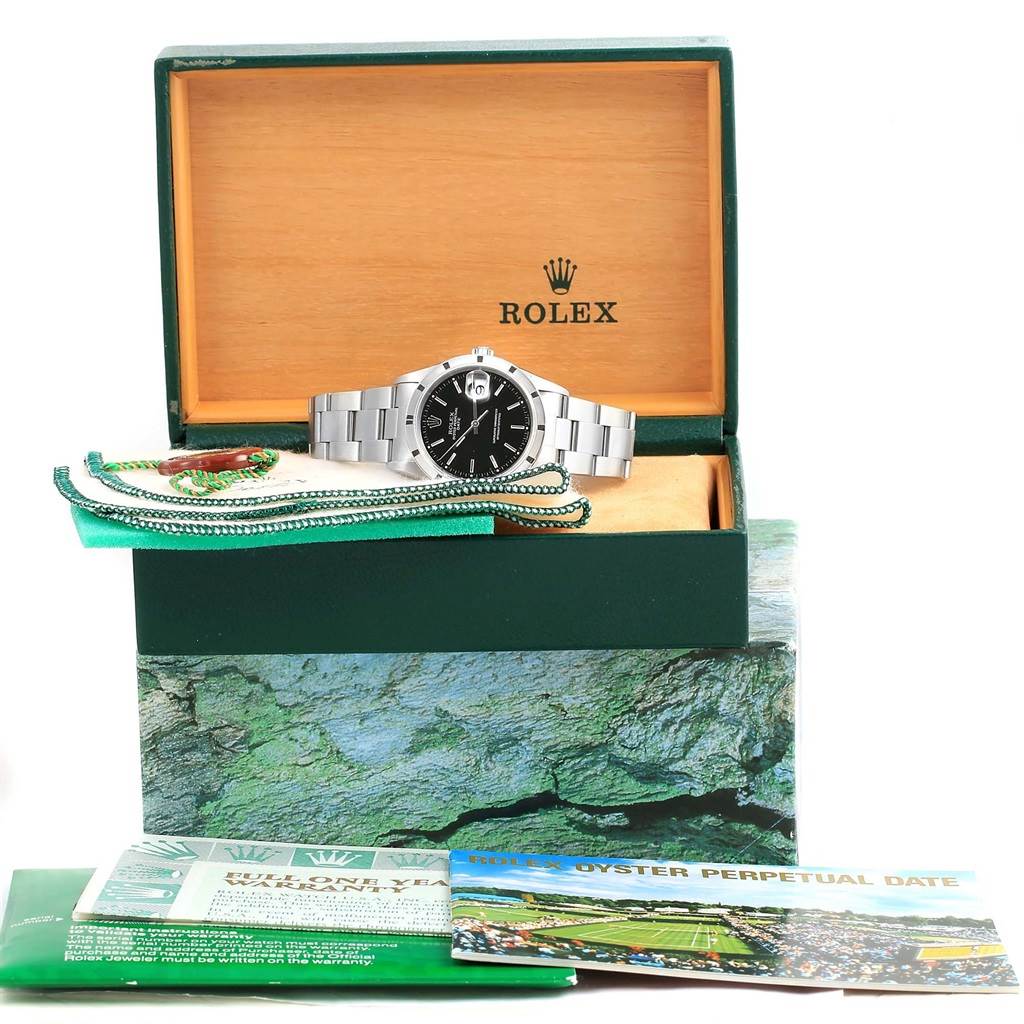 This image shows the Rolex Date 15210 Men's Stainless Steel Black Dial 15210 Men's Stainless Steel Black Dial watch placed in its open box with warranty cards and a green tag in front.