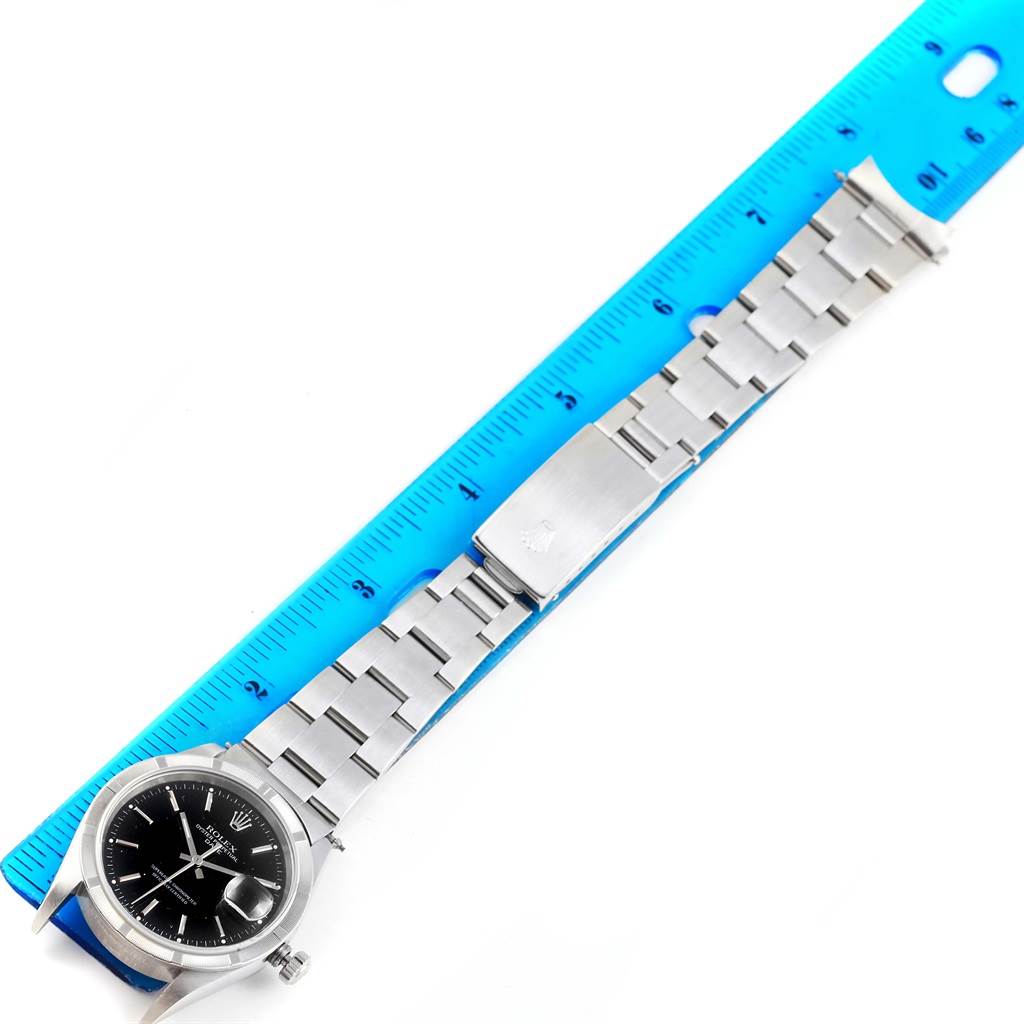 The Rolex Date 15210 Men's Stainless Steel Black Dial 15210 Men's Stainless Steel Black Dial model watch is shown in a horizontal position with the full length of the band and face visible alongside a ruler.