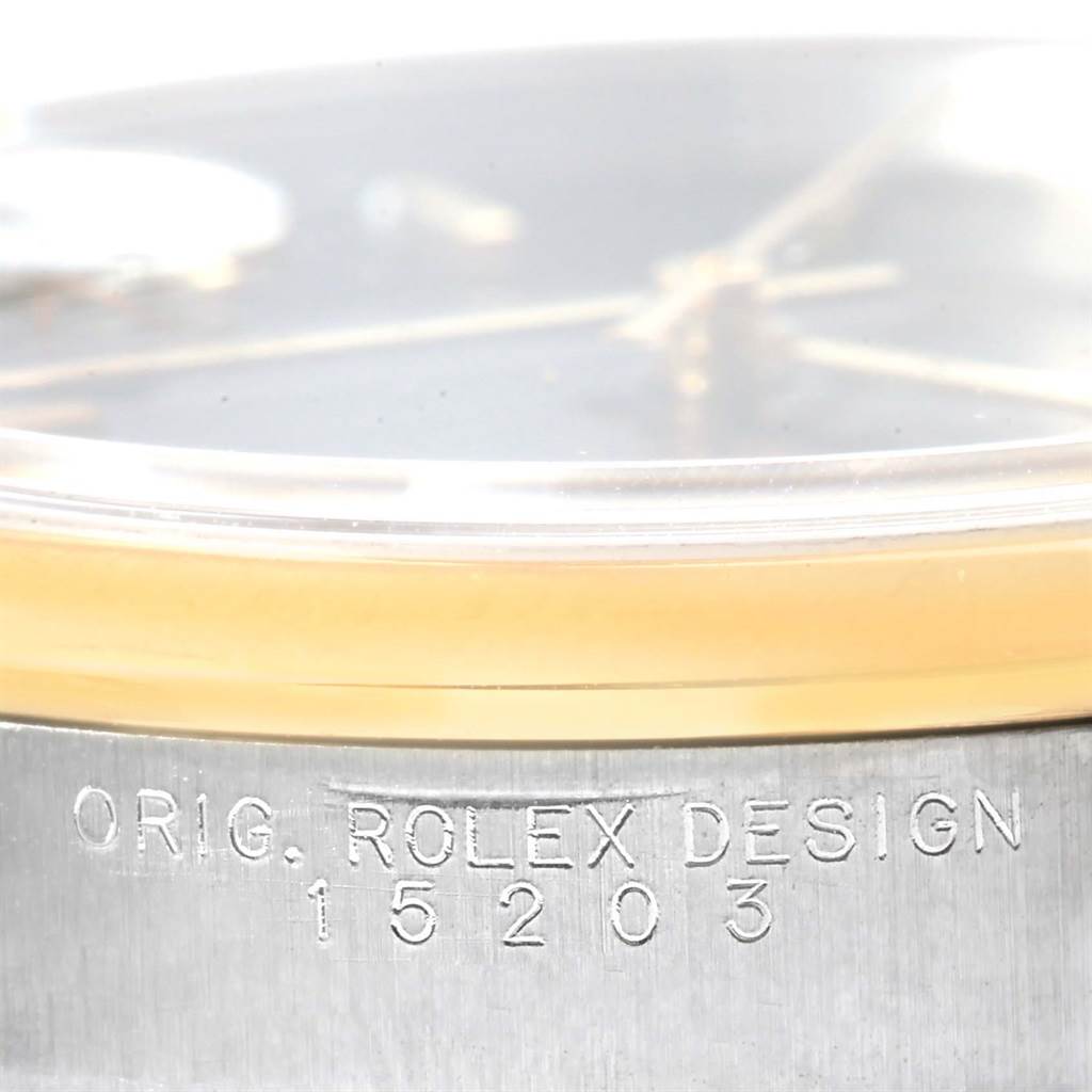 The image shows a close-up of the side of a Rolex Date 15203 Men's Steel and Gold (two tone) Black Dial 15203 Men's Steel and Gold (two tone) Black Dial model watch, highlighting the engraved model number 15203 and "ORIG. ROLEX DESIGN" inscription.