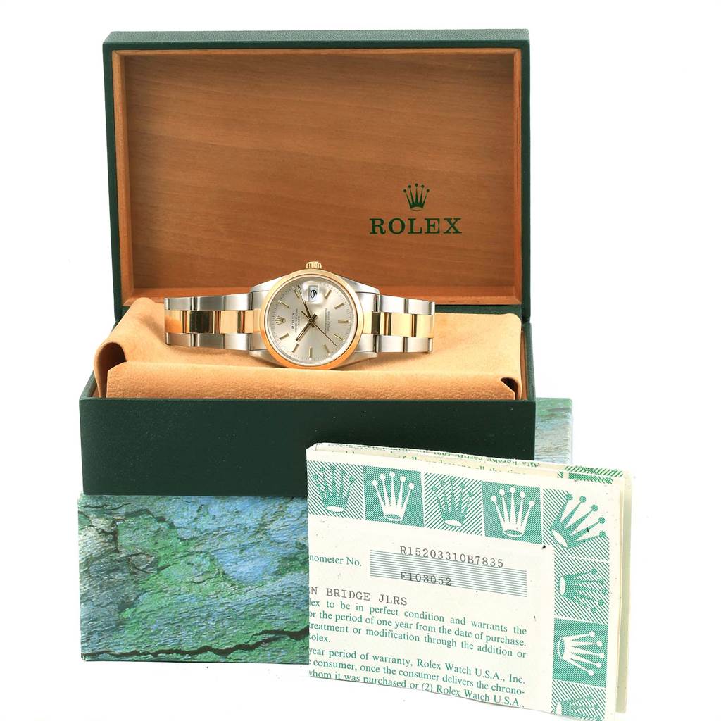 The Rolex Date 15203 Men's Steel and Gold (two tone) Silver Dial 15203 Men's Steel and Gold (two tone) Silver Dial watch is shown at a front angle, within its box and accompanied by warranty cards.