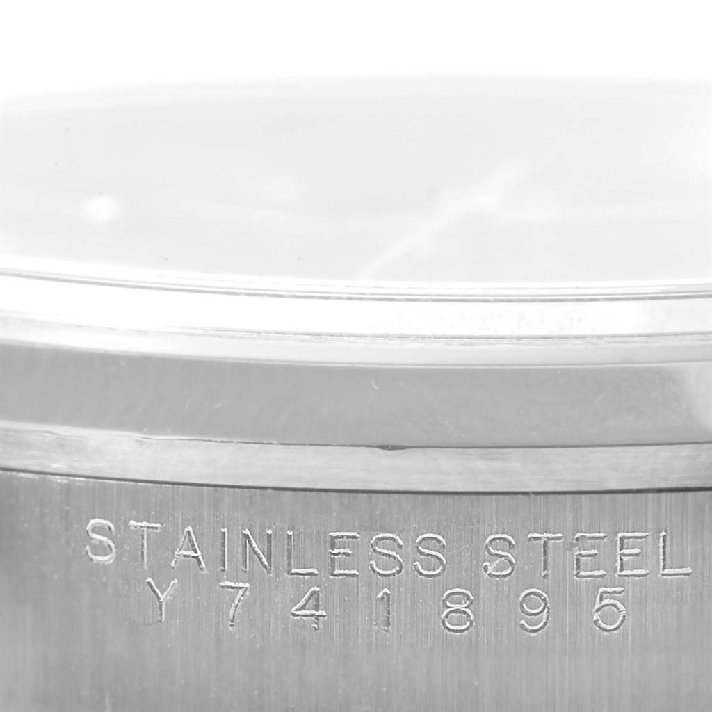 The image shows a close-up angle of the case side for a Rolex Date 15200 Men's Stainless Steel Blue Dial 15200 Men's Stainless Steel Blue Dial model watch, revealing its stainless steel material and serial number.