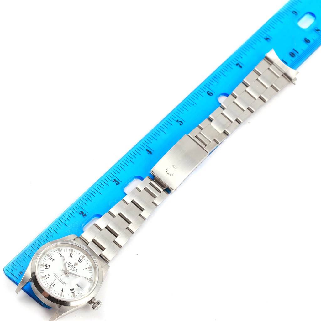 The image shows a flat, horizontal view of a Rolex Date 15200 Men's Stainless Steel White Dial 15200 Men's Stainless Steel White Dial model watch laid next to a blue ruler.