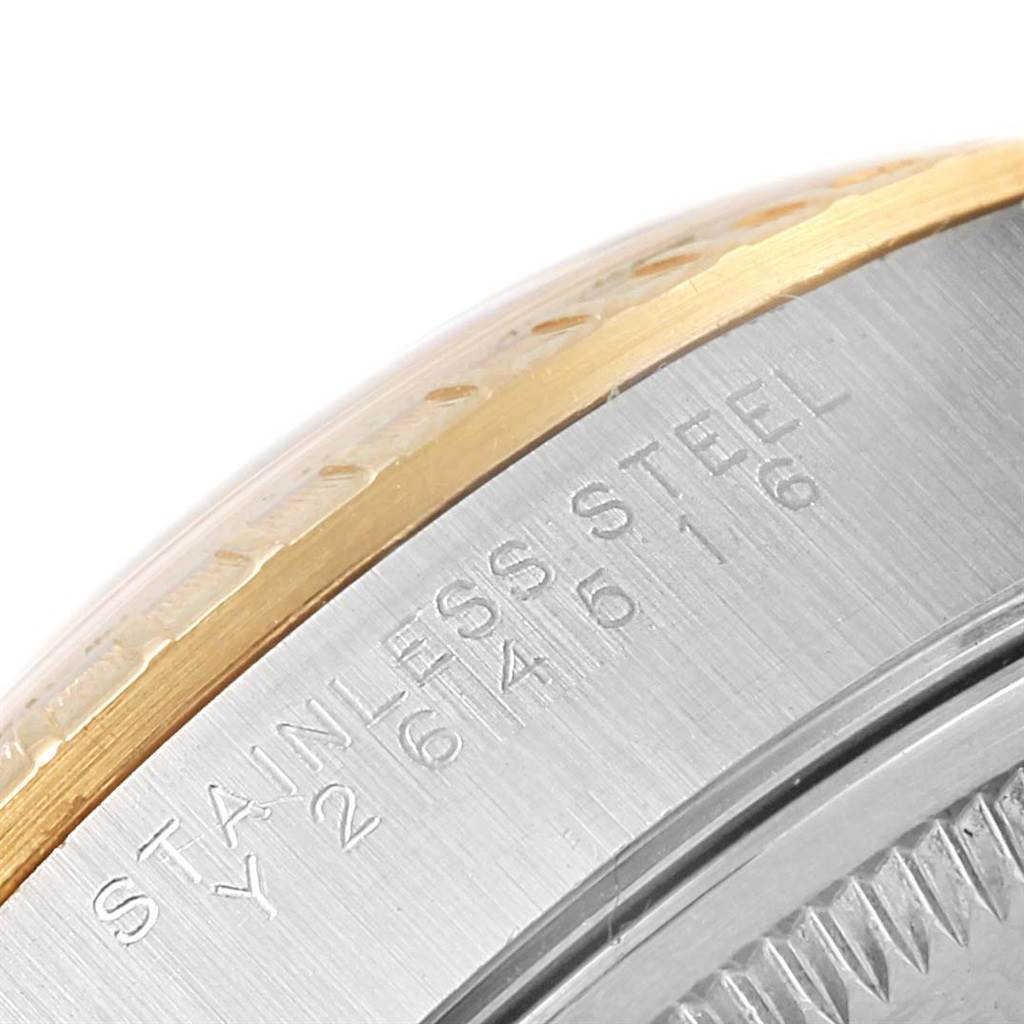 The image shows a close-up of the case back and edge of a Rolex Date 15223 Men's Steel and Gold (two tone) Champagne Dial 15223 Men's Steel and Gold (two tone) Champagne Dial model watch, highlighting the stainless steel engraving.
