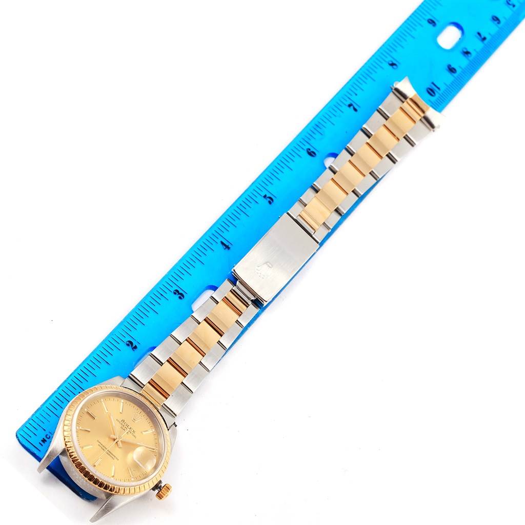The image shows a Rolex Date 15223 Men's Steel and Gold (two tone) Champagne Dial 15223 Men's Steel and Gold (two tone) Champagne Dial model watch laying flat with a two-tone metal bracelet, measured against a blue ruler.