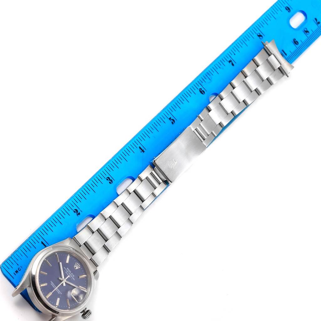 This image shows a Rolex Date 15200 Men's Stainless Steel Blue Dial 15200 Men's Stainless Steel Blue Dial model watch laid flat with its band and clasp extended next to a ruler.