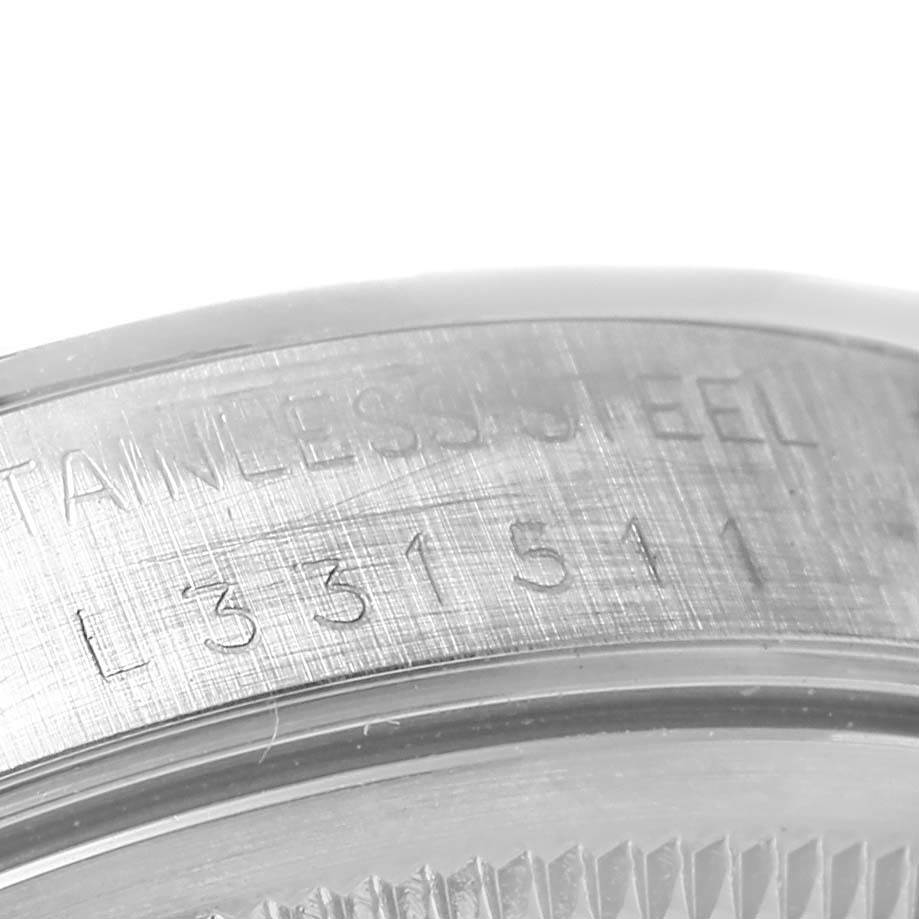 The image shows a close-up of the case back edge of a Rolex Date 15200 Men's Stainless Steel Blue Dial 15200 Men's Stainless Steel Blue Dial model watch, highlighting the stainless steel and serial number engraving.