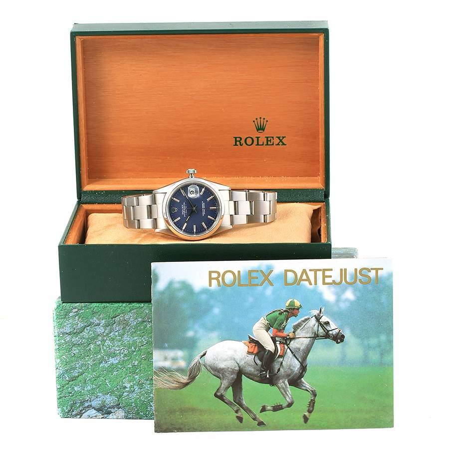 The image shows a Rolex Date 15200 Men's Stainless Steel Blue Dial 15200 Men's Stainless Steel Blue Dialjust watch, head-on, inside its opened box with the brochure in front.