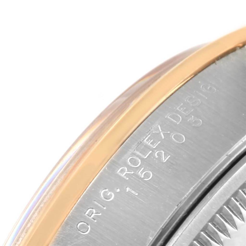 This image shows a close-up of the side of a Rolex Date 15203 Men's Steel and Gold (two tone) Blue Dial 15203 Men's Steel and Gold (two tone) Blue Dial model watch, focusing on its serial engraving and part of the bezel.
