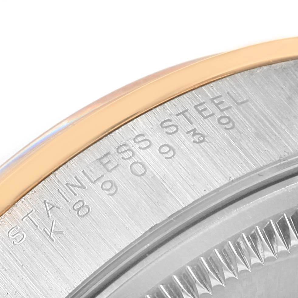 The image shows a close-up of the case back edge of a Rolex Date 15203 Men's Steel and Gold (two tone) Blue Dial 15203 Men's Steel and Gold (two tone) Blue Dial model watch, highlighting the stainless steel marking and part of the serial number.