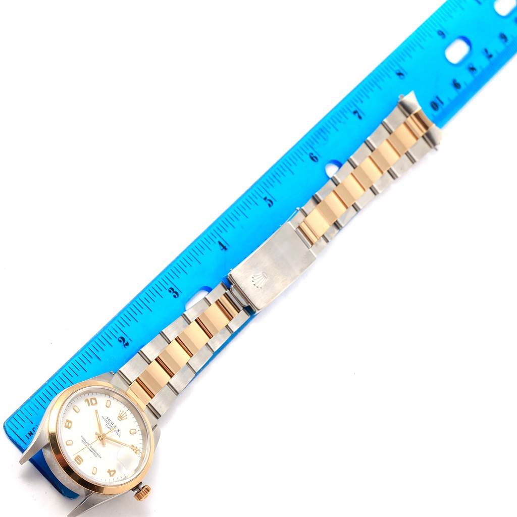 The image shows the face and bracelet of a Rolex Date 15203 Men's Steel and Gold (two tone) White Dial 15203 Men's Steel and Gold (two tone) White Dial model watch, aligned beside a blue ruler for measurement.