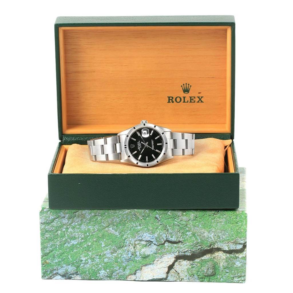 The image shows a Rolex Date 15210 Men's Stainless Steel Black Dial 15210 Men's Stainless Steel Black Dial watch with a black dial in its open green and beige box, viewed from the front.
