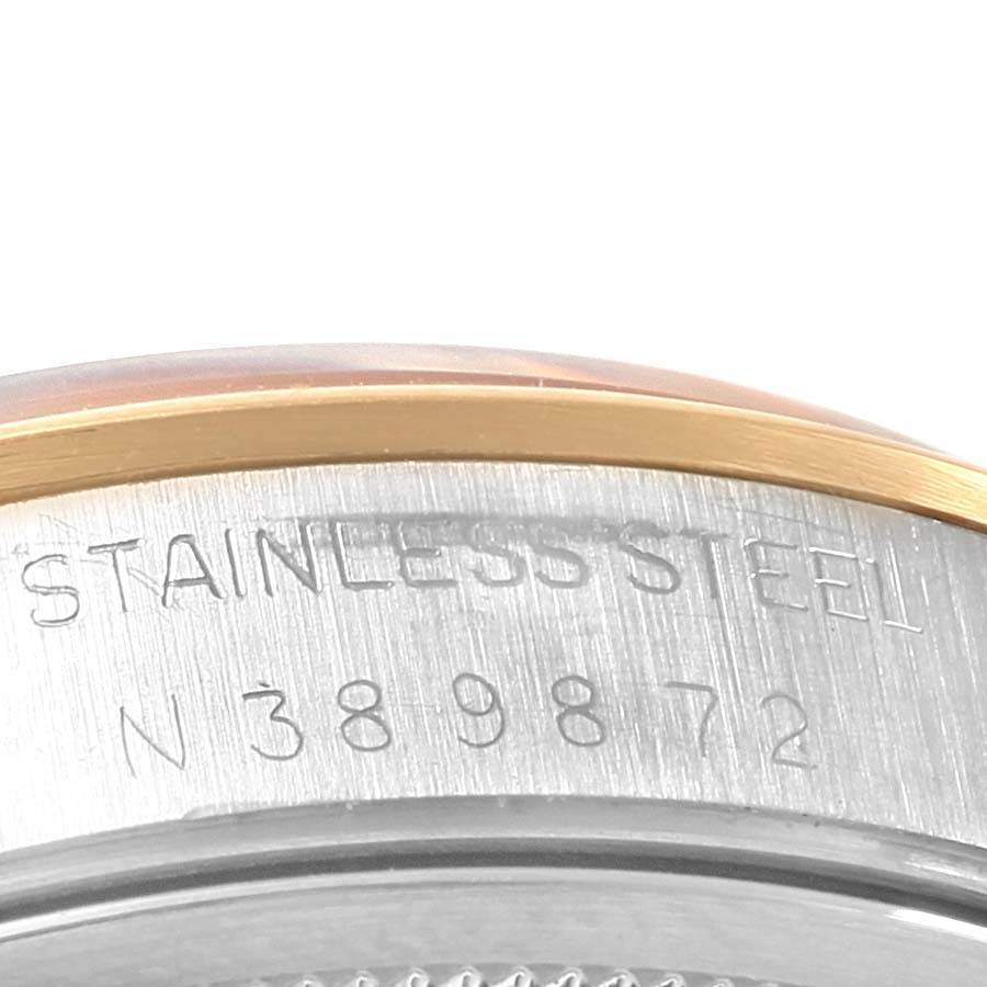 This image shows a close-up of the edge and caseback of a Rolex Date 15203 Men's Steel and Gold (two tone) Black Dial 15203 Men's Steel and Gold (two tone) Black Dial model, highlighting the stainless steel text and part of the serial number.