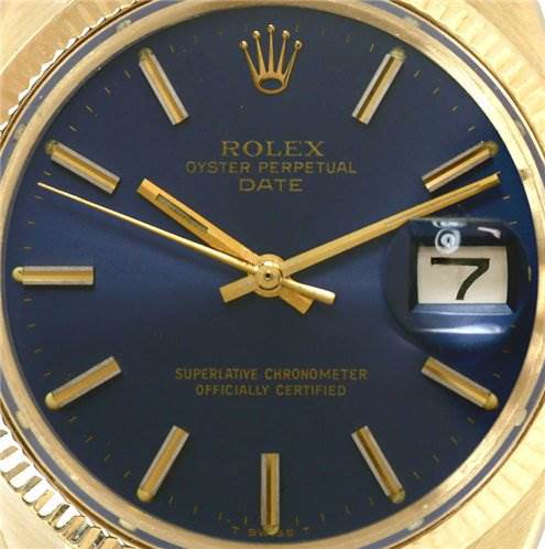 The image shows a close-up of the dial and bezel of a Rolex Date model, highlighting the blue face, date window, and markers.