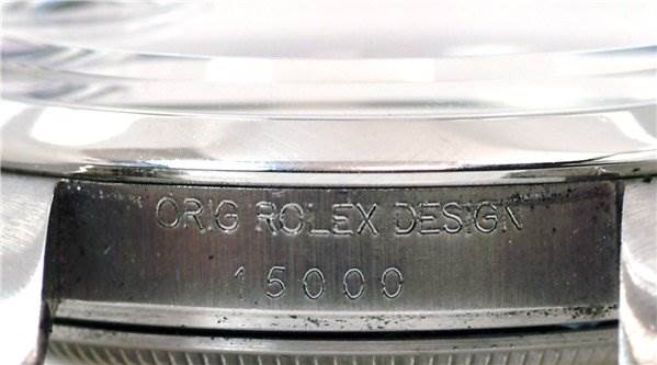 The image shows a close-up of the case side, serial number, and model engraving on a Rolex Date 15000 Men's Stainless Steel Purple Dial 15000 Men's Stainless Steel Purple Dial watch.