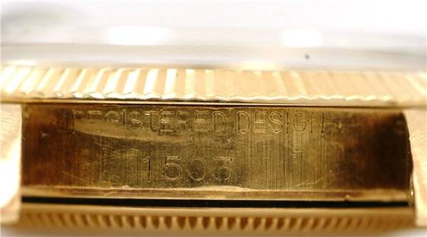 The image shows a close-up of the case side of a Rolex Date 1503 Men's Yellow Gold Black Dial 1503 Men's Yellow Gold Black Dial watch, highlighting the "Registered Design" and model number 1503.