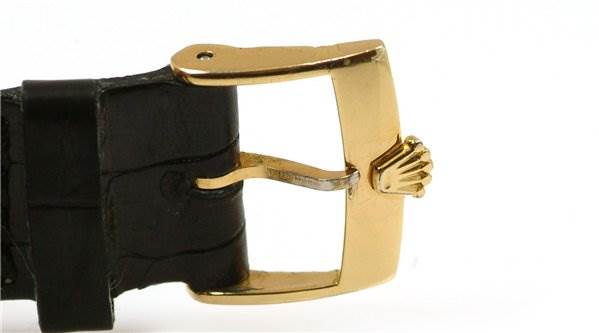 The image shows a close-up of the gold buckle on a leather strap of a Rolex Date 1503 Men's Yellow Gold Black Dial 1503 Men's Yellow Gold Black Dial watch.