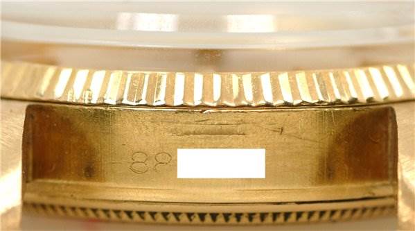 This image shows a close-up of the serial number area and the fluted bezel of a Rolex Date 1503 Men's Yellow Gold Champagne Dial 1503 Men's Yellow Gold Champagne Dial model watch.