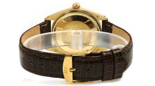 The image shows the back view and strap of a Rolex Date 1503 Men's Yellow Gold Champagne Dial 1503 Men's Yellow Gold Champagne Dial model watch, featuring a gold case and brown leather strap.