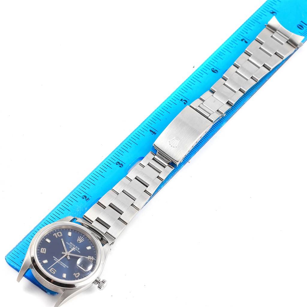 The image shows a Rolex Date 15200 Men's Stainless Steel Blue Dial 15200 Men's Stainless Steel Blue Dial model wristwatch, laid flat with its bracelet and clasp measured against a blue ruler.